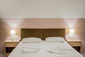 1 cama con 2 toallas y 2 lámparas en Stefania Studios by Estia, en Stalida