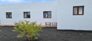 un edificio blanco con ventanas laterales en Casa Rural Yeyo en el cráter del volcán, en Tinguatón