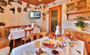 una sala da pranzo con tavolo e cibo di Pension Maria a Hauzenberg