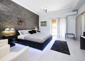 ein Schlafzimmer mit einem Bett und einer Ziegelwand in der Unterkunft Fantastic Dream in Catania