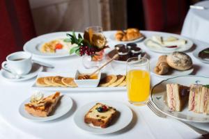 a table topped with plates of desserts and orange juice at Starhotels Michelangelo Rome in Rome