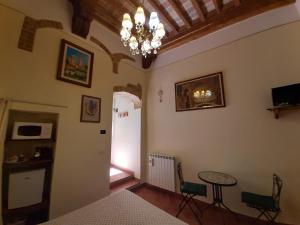 una camera da letto con lampadario pendente e tavolo e sedie di Locazione Turistica Totti a San Gimignano