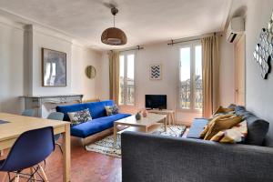 uma sala de estar com um sofá azul e uma mesa em NOCNOC - Le Republique em Marselha