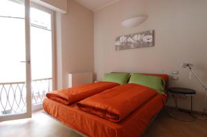 een bed met een oranje deken in een kamer bij UR-NEST Piazza Maggiore in Bologna