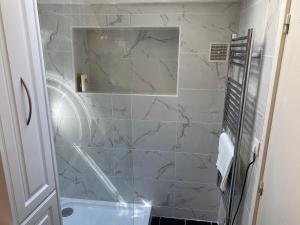 uma casa de banho com chuveiro e paredes em mármore branco em Bijou Apartment in Safranier - Old Town Antibes em Antibes