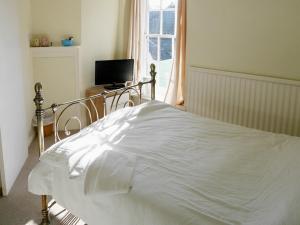 a white bed in a bedroom with a window at The Saracens Head Hotel in Highworth