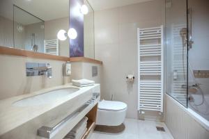 a bathroom with a toilet, sink and shower at Hotel Park - Sava Hotels & Resorts in Bled