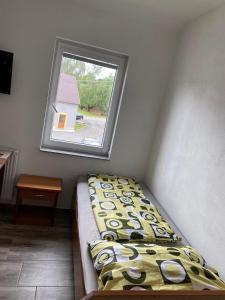 a small room with a bed and a window at Ubytovani Vysocany in Bor