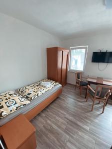 a bedroom with a bed and a table and chairs at Ubytovani Vysocany in Bor