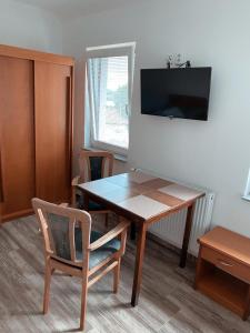 a room with a table and chairs and a television at Ubytovani Vysocany in Bor
