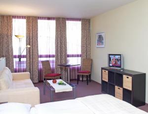 um quarto de hotel com uma cama, um sofá e uma mesa em Parkhotel Eisenstadt em Eisenstadt