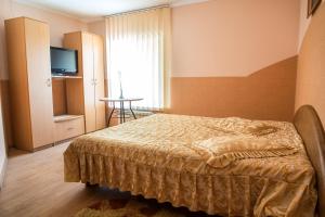 - une chambre avec un lit, une télévision et une table dans l'établissement Venezia, à Tchernivtsi