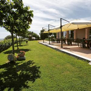 un jardín con mesas y sillas y un patio en Agriturismo Colle Tripio, en Guardiagrele
