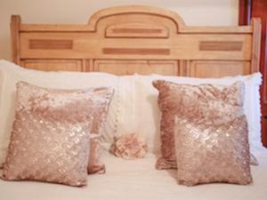 a bed with two pillows and a wooden headboard at The Shepherd's Purse in Whitby