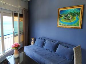 un divano blu in soggiorno con finestra di Apartmani Orange Dreams a Sutomore