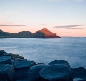 a large group of rocks in the water at sunset at Finn McCools Giants Causeway Hostel in Bushmills