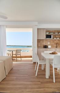 una cucina e una sala da pranzo con tavolo e vista sull'oceano di Apartamentos Sabina Playa a La Savina