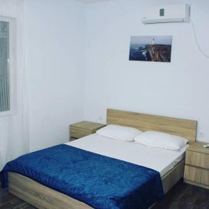 1 dormitorio con 1 cama grande con manta azul en Hotel Sunrise in Ureki en Ureki