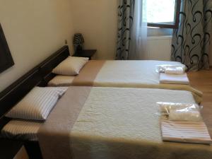 Dos camas en un dormitorio con toallas. en Guest House Kakheti, en Kvareli