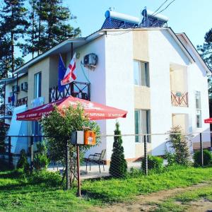 a building with a red umbrella in front of it at Hotel Sunrise in Ureki in Ureki