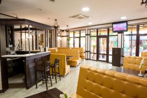 a restaurant with yellow chairs and a bar at Venezia in Chernivtsi