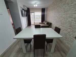 a dining room with a white table and chairs at Apartament Posada in Curtea de Argeş
