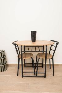 einen Tisch und Stühle mit einer Vase darüber in der Unterkunft Studio Apartment Vukcevic in Podgorica