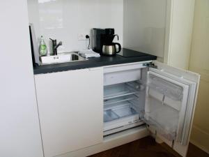 a kitchen with an open refrigerator and a sink at Altes Forstamt in Gernsbach