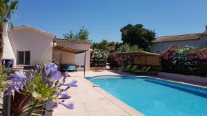 uma casa com piscina com flores roxas em Gîte La Volière em Cardet