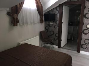 1 dormitorio con cama, silla y espejo en Petrol-İş İstanbul Misafirhanesi, en Estambul