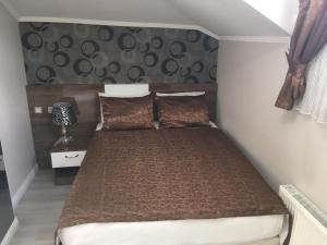 1 dormitorio con 1 cama con edredón marrón en Petrol-İş İstanbul Misafirhanesi, en Estambul