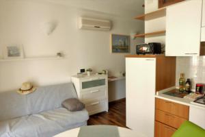 Il comprend un petit salon avec un canapé et une cuisine. dans l'établissement Studio Flat close to Terme, à Sirmione