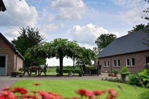 einen Garten mit einem Tisch und einem Baum im Hof in der Unterkunft De Lakenvelder B&B Eersel in Eersel