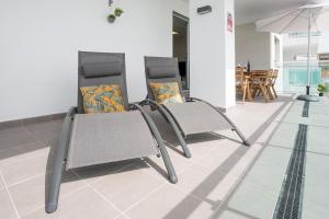 2 sillas y una sombrilla en una habitación en Seafront Duna Beach Luxury Apartment, en Torrox