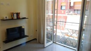 ein Wohnzimmer mit einem TV und einer Glasschiebetür in der Unterkunft Aurelia - Apartment Begonia in Rom