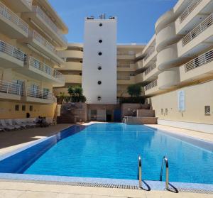 a swimming pool in front of a building at Marina Vilamoura Apartment in Vilamoura