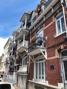 un edificio in mattoni rossi con balconi su una strada di VILLA JULIETTE a Dunkerque