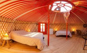 1 dormitorio con tienda de campaña con 2 camas y ventana en Camping El Roble, en Valderrobres