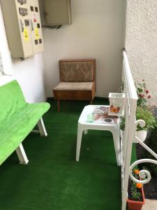 Zimmer mit grünem Teppich, Tisch und Stuhl in der Unterkunft House Centrul Istoric in Sibiu