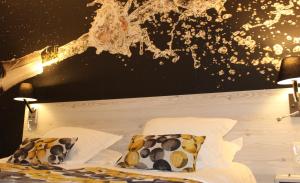uma cama com lençóis e almofadas brancos e um candeeiro em Hotel de Champagne em Épernay