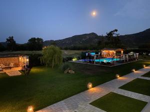 a backyard with a pool and a house with lights at A Ponte Studios & Apartments in Sykia Chalkidikis