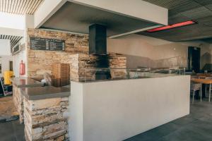 a restaurant with a counter and a brick wall at FarOut - BeachResort & Camping in Mylopotas
