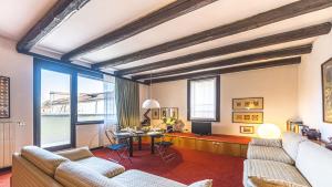 a living room with couches and a table with a television at Penthouse Accademia in Venice