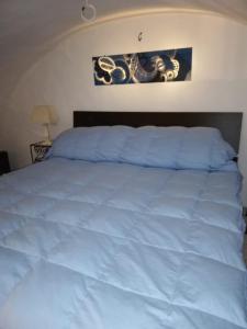 a bed with a white bedspread on top of it at Appartamento centro storico in Scanno