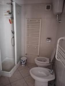 a white bathroom with a toilet and a shower at Appartamento centro storico in Scanno
