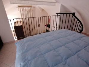 a bed with a blue blanket in a bedroom at Appartamento centro storico in Scanno