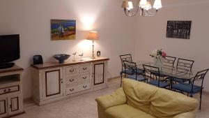 a living room with a couch and a table and a tv at Marina Vilamoura Apartment in Vilamoura