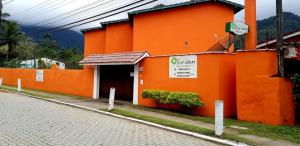 an orange building on the side of a street at VILLA GARDEN - Suites in Maresias