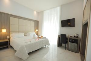 una camera con un grande letto bianco e una scrivania di Hotel Garibaldi a Napoli
