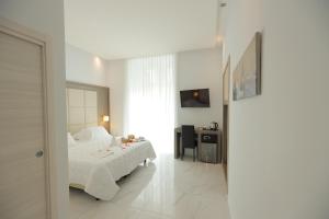 una camera con letto, scrivania e specchio di Hotel Garibaldi a Napoli